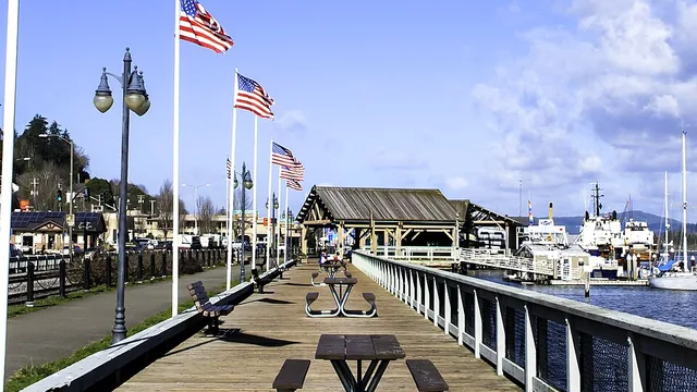 The wooden Coos Bay Boardwalk with flags along the waterfront